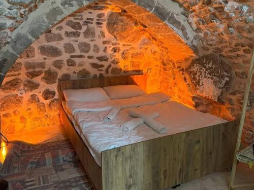 a bed in a room with a brick wall at Alkan mozayik otel in Urfa
