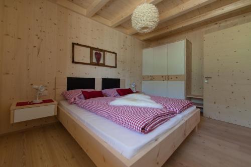 a bedroom with a large bed with red pillows at Winklerhof Apartments in Brunico