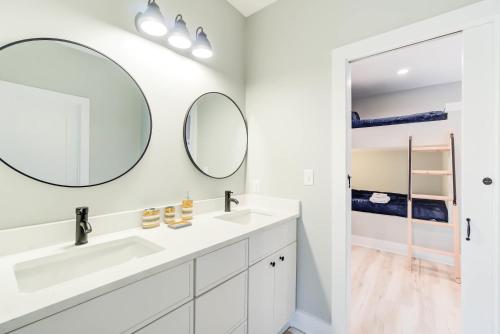 a bathroom with two sinks and two mirrors at Modern Family Cabin 1 min to Bryce Fire Pit KING Bed in Basye