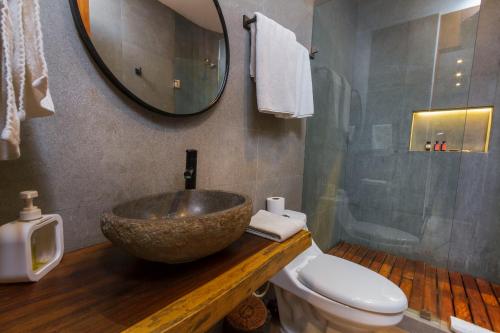 a bathroom with a bowl sink and a toilet at Phimai, Tu Lugar Magico En Tulum in Tulum