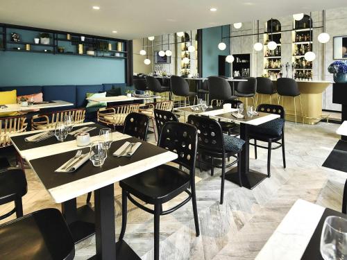 a restaurant with tables and chairs and a bar at ibis Styles Dijon Central in Dijon