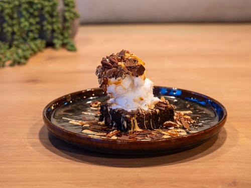 a chocolate dessert with ice cream on a plate on a table at ibis Poitiers Sud in Poitiers