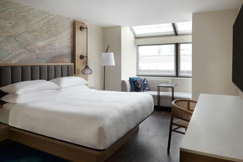 a bedroom with a large white bed and a chair at Kingston Marriott Hotel in Kingston