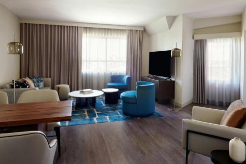 a living room with blue chairs and a couch at Kingston Marriott Hotel in Kingston