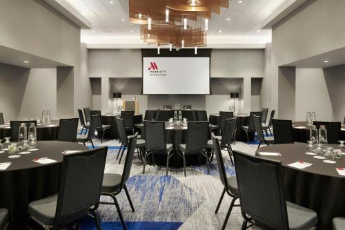 a conference room with tables and chairs and a screen at Kingston Marriott Hotel in Kingston