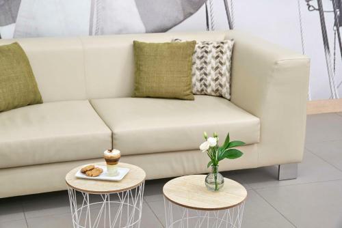 a living room with a couch and two tables at NH Campo Cartagena in Cartagena