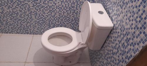 a bathroom with a white toilet in a blue tiled wall at Hostel da Lua in Barreirinhas