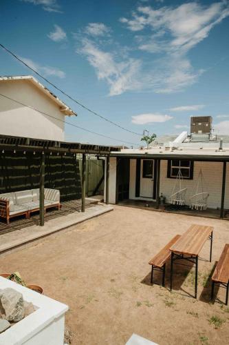 a patio with a wooden bench in front of a house at Joshua Tree - Under the Stars-Pool, Spa & Fire pit in Yucca Valley