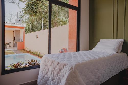 Un dormitorio con una cama y una ventana grande. en Casa D'Mata Experience unforgettable moments in FOZ, en Foz do Iguaçu