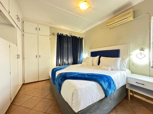a bedroom with a large bed with a blue and white blanket at 3 Bedroom House in Nelspruit in Nelspruit