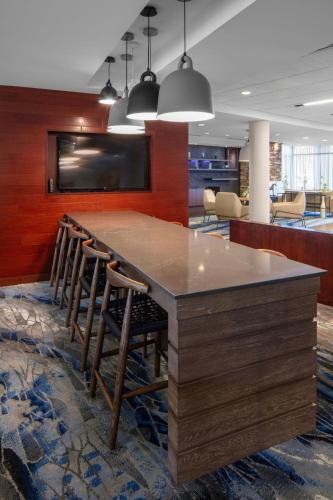 a large wooden bar with stools in an office lobby at Fairfield Inn & Suites by Marriott Geneva Finger Lakes in Geneva