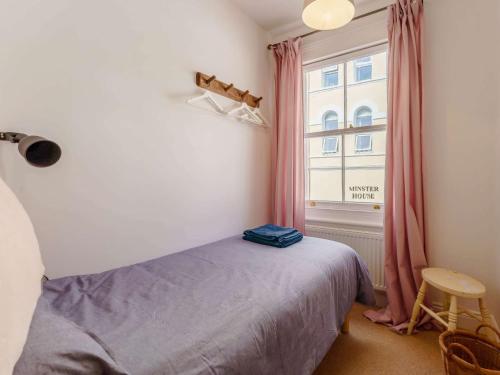 a bedroom with a bed and a window with pink curtains at 3 Bed in Eastbourne 83924 in Eastbourne
