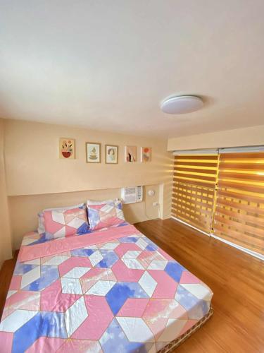 a bedroom with a bed with a colorful quilt at Loft house @ Patar beach in Bolinao