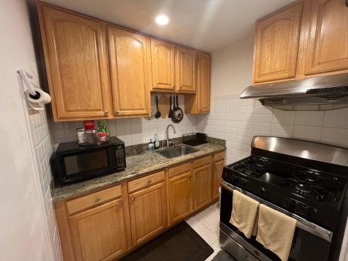 a kitchen with wooden cabinets and a black stove at San Francisco 2 Bedroom with Parking near BART in San Francisco