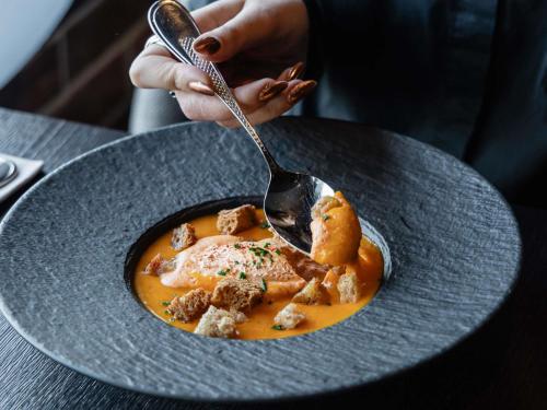 a person eating a bowl of food with a spoon at Pullman Bordeaux Lac in Bordeaux