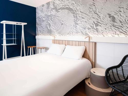 a bedroom with a white bed and a blue wall at ibis Macon Sud Crêches in Crêches-sur-Saône