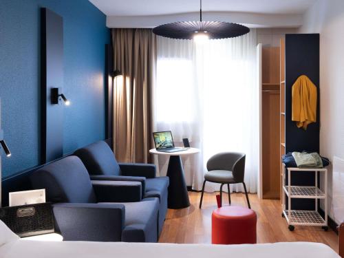 a room with a couch and a chair and a table at ibis Macon Sud Crêches in Crêches-sur-Saône