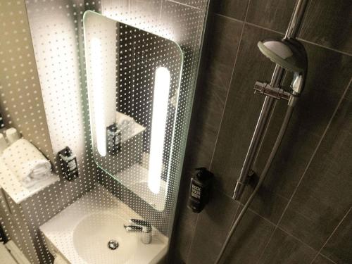 a bathroom with a sink and a mirror at Hotel ibis Narbonne in Narbonne