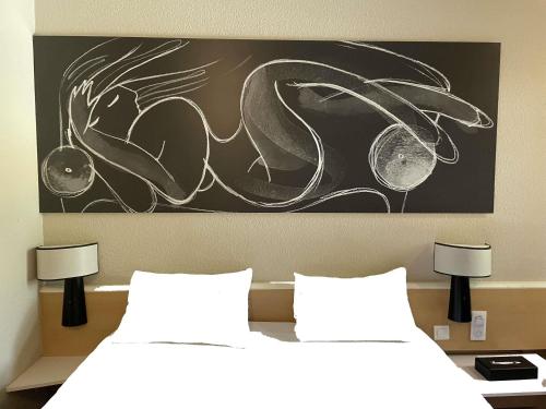two beds in a room with a painting on the wall at Hotel ibis Narbonne in Narbonne