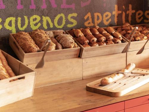 a bakery with several boxes of loaves of bread at Hotel ibis Narbonne in Narbonne