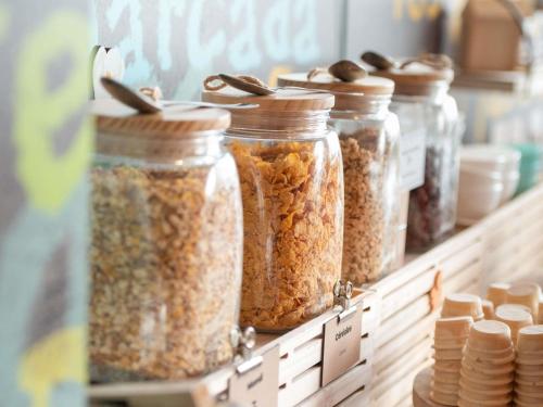 a row of jars of nuts on a shelf at Hotel ibis Narbonne in Narbonne