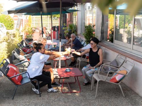 a group of people sitting at tables outside a restaurant at Hotel ibis Narbonne in Narbonne
