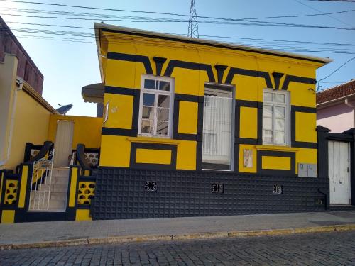 a yellow and black house on the side of a street at Pousada Divino Espírito Santo in Paraisópolis