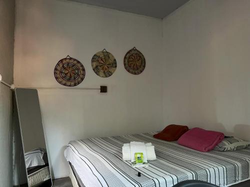 a bedroom with a bed with three plates on the wall at Pousada - Casa dos Paiva in Barreirinhas