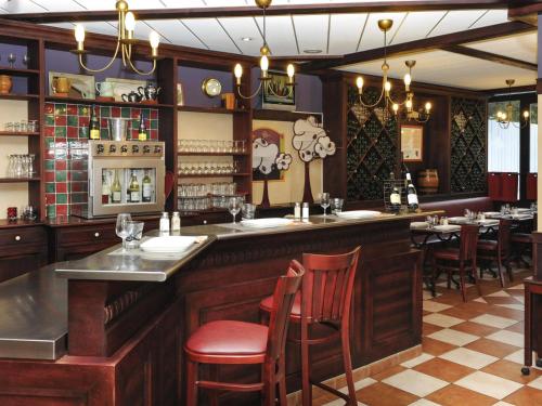 a bar in a restaurant with chairs and tables at ibis Chartres Ouest Luce in Chartres