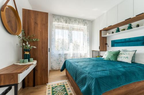 une chambre avec un lit bleu et une fenêtre dans l'établissement Urban Modern Apartaments 5, à Jelenia Góra
