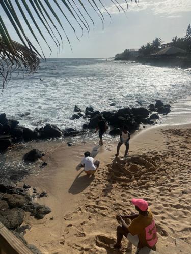 a group of people playing in the sand on the beach at Appartement spacieux, piscine, balcon, vue sur mer et salle de sport in Dakar