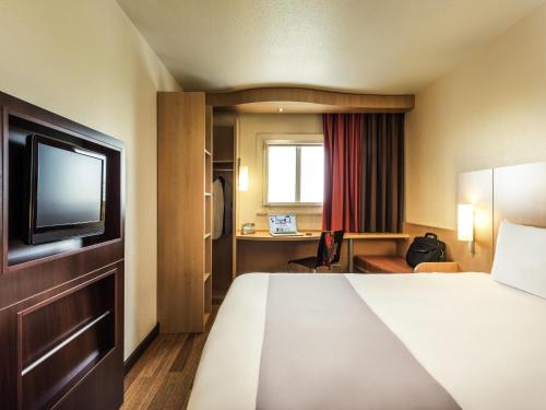 a hotel room with a bed and a television at ibis Paris Montmartre Sacré-Coeur in Paris