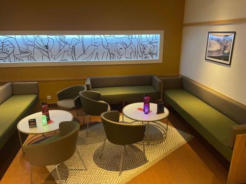 a waiting room with two tables and chairs at ibis Paris Montmartre Sacré-Coeur in Paris