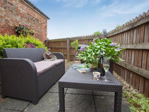 a patio with a chair and a table with flowers at 2 Bed in Howden G0113 in Saltmarshe
