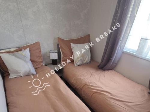 two beds sitting next to each other in a bedroom at Stylish Family Caravan Retreat - Seal Bay, Selsey in Chichester