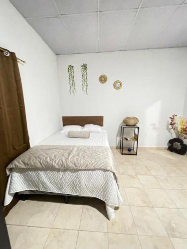 a bedroom with a bed in a white room at La ceiba surf in El Sunzal