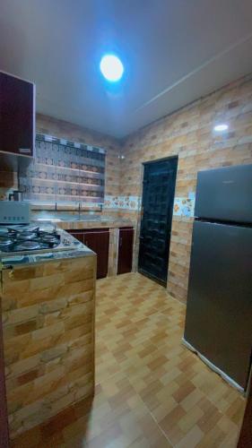 a kitchen with a refrigerator and a stove in it at Rapid Roost Apartments in Umuahia