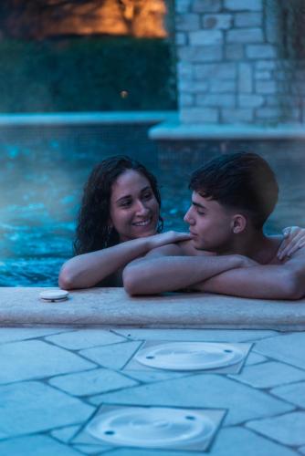 a woman and a man in a swimming pool at Villa Caribe Resort & Spa in Spigno Saturnia
