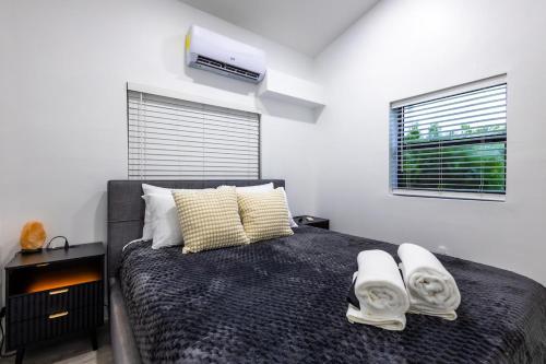 a bedroom with a large bed with towels on it at The Side Villa in Miami