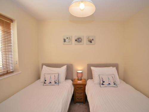 two twin beds in a bedroom with a night stand at 2 Bed in Brixham BX054 in Brixham