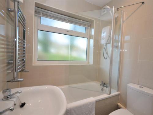 a bathroom with a sink and a tub and a window at 2 Bed in Brixham BX054 in Brixham