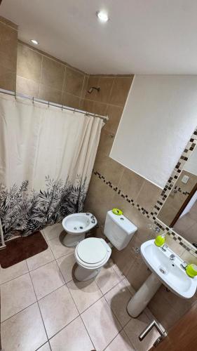 a bathroom with two toilets and a sink at Catamarca Apart in Villa María