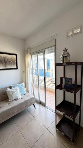 a living room with a couch in front of a sliding glass door at Catamarca Apart in Villa María