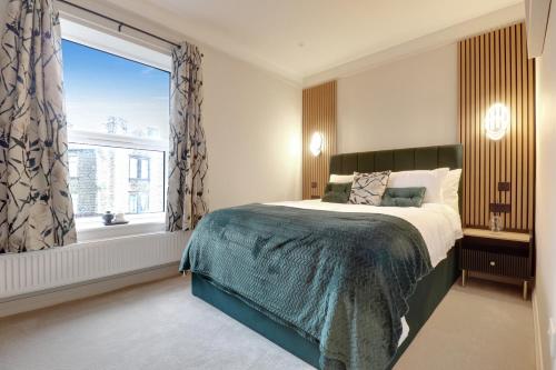 a bedroom with a bed and a large window at Luxury 2 Bed House in Lindley Huddersfield 2 mins from HRI 5 mins from Town Centre and M62 in Lindley