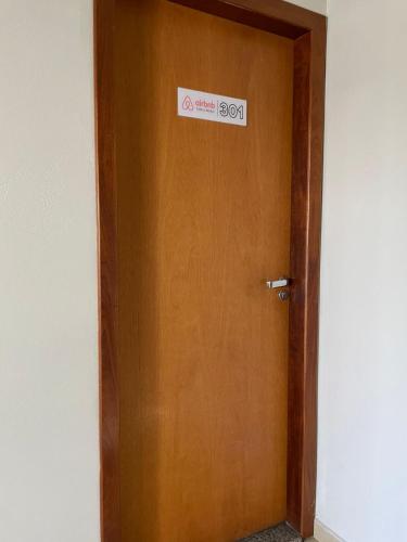 a wooden door with a sign on it at Flat Centro 301 in Tangara da Serra