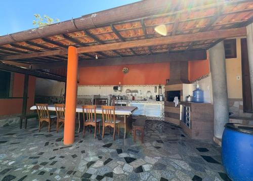 a kitchen with a table and chairs in a kitchen at Recanto Búzios Arpoador Suítes in Búzios