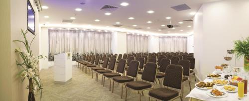 a row of chairs in a room with food on tables at Blanca Hotel in Izmir