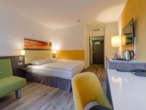 a hotel room with two beds and a kitchen at Mercure Hotel Köln West in Cologne