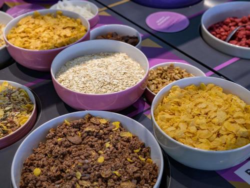a table topped with bowls of different types of food at Mercure Hotel Köln West in Cologne