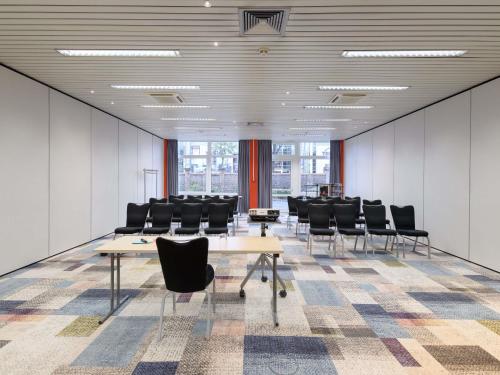 a conference room with chairs and tables in an office at Mercure Hotel Köln West in Cologne